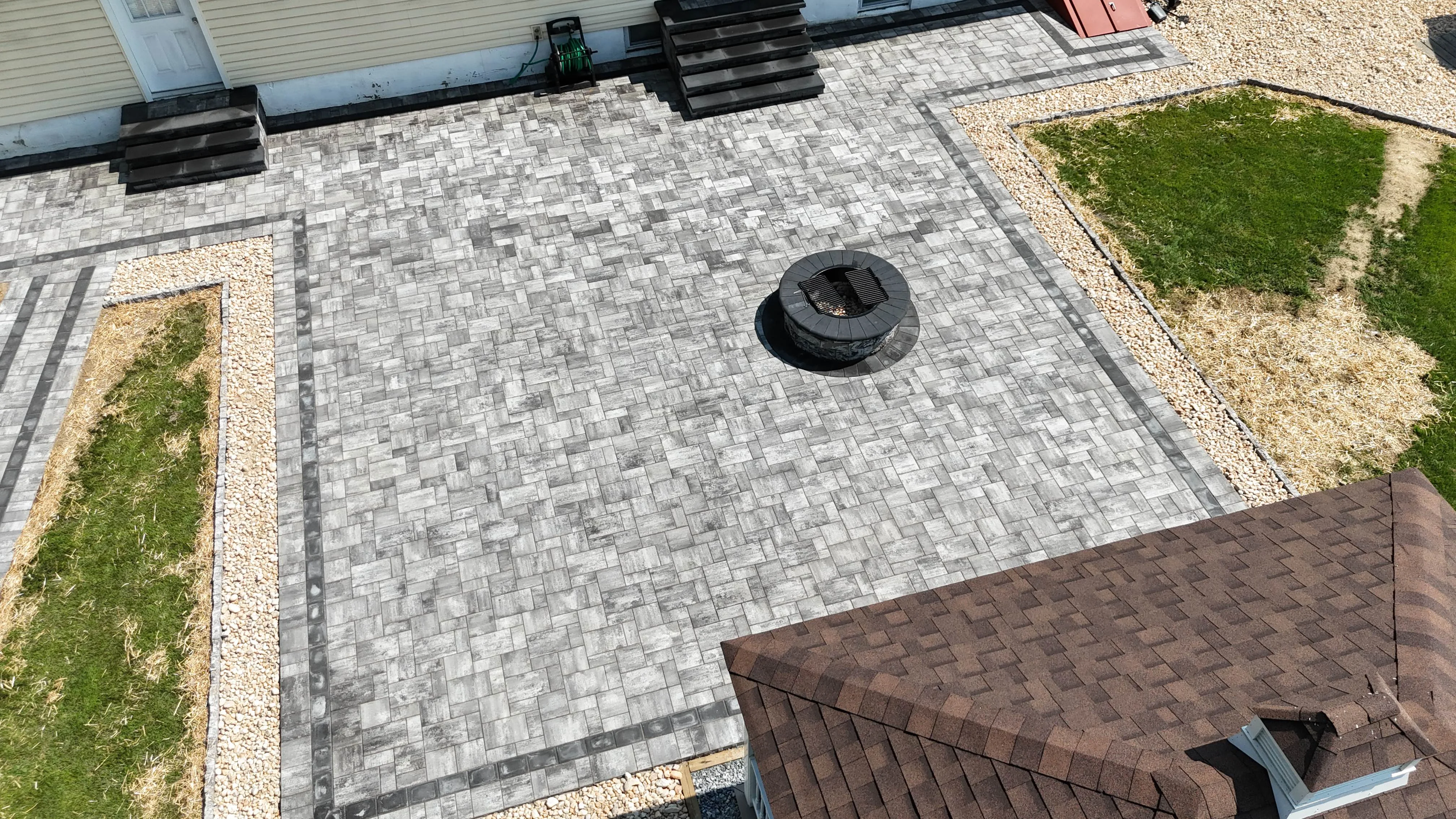 A paver patio with integrated steps and fire pit