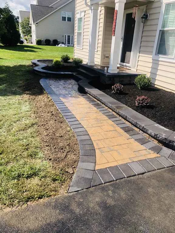 Paver walkway with planter bed and steps.